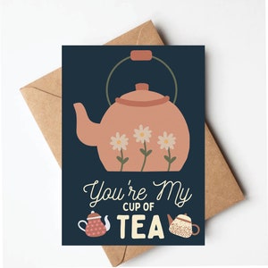 May include: A navy blue card with a pink teapot with white flowers and the text "You're My Cup of Tea". Two smaller teapots are at the bottom of the card.