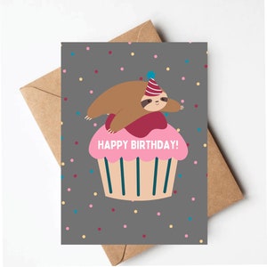 Puede incluir: Una tarjeta gris con una magdalena rosa y un perezoso marr&oacute;n que lleva un gorro de fiesta. La magdalena tiene glaseado blanco y chispas. El texto "HAPPY BIRTHDAY!" est&aacute; en la magdalena. El fondo es gris con confeti de colores.