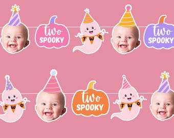 May include: A pink background with multiple stickers featuring a baby's face wearing a party hat, a ghost with a banner that says "TWO", and pumpkins with the text "two spooky".