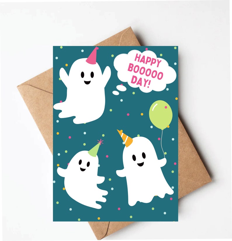 May include: A teal blue card with three white ghosts wearing party hats. The ghosts have happy faces and one is holding a green balloon. The card says "Happy Boooooo Day!" in a white speech bubble.