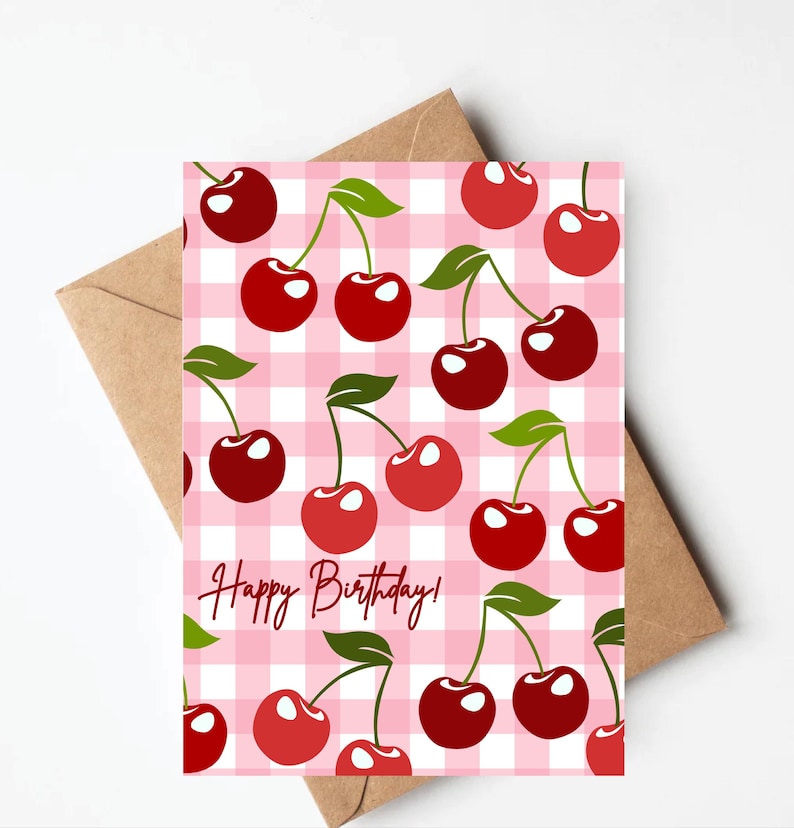 K&ouml;nnte beinhalten: Eine pinkfarbene und wei&szlig;e Gingham-Karte mit roten Kirschen und dem Text "Happy Birthday!"