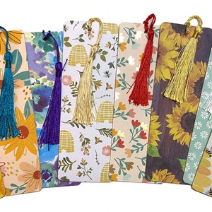 May include: Set of ten colorful bookmarks with various floral and geometric patterns. Each bookmark features a tassel in a different color, including teal, purple, gold, red, white, and navy blue.