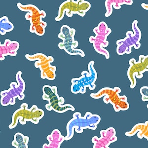May include: A pattern of colorful lizard stickers on a dark blue background. The lizards are in various colors, including blue, pink, orange, green, and purple, with white outlines. The lizards are in different poses.