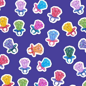 Puede incluir: Un patrón de anillos de caramelo de dibujos animados coloridos con grandes gemas facetadas en varios colores, incluyendo rojo, amarillo, verde, azul y morado, sobre un fondo azul oscuro. Las bases de los anillos son de colores coordinados.