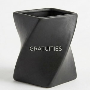 May include: Black, twisted ceramic container with the word "GRATUITIES" in white. The square-shaped top leads to a spiraling design, creating a unique, modern aesthetic. The container is likely used for collecting tips or small items.