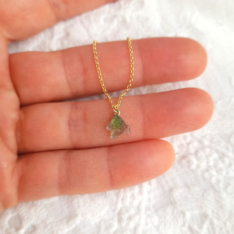 K&ouml;nnte beinhalten: Eine goldene Kettenkette mit einem kleinen, rohen gr&uuml;nen Kristallanh&auml;nger.