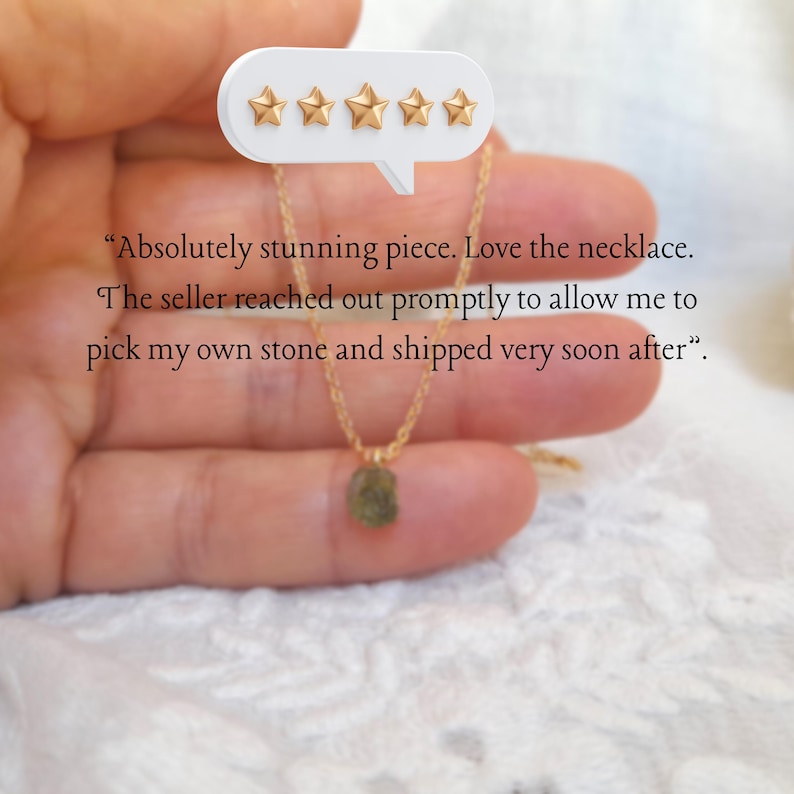 May include: A delicate gold-toned chain necklace featuring a small, raw, olive-green stone pendant. The image includes a five-star rating graphic and the text: "Absolutely stunning piece. Love the necklace. The seller reached out promptly to allow me to pick my own stone and shipped very soon after".