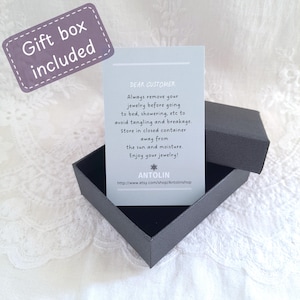 May include: A black jewellery gift box containing a light blue care instruction card with the text: DEAR CUSTOMER, Always remove your jewellery before going to bed, showering, etc to avoid tangling and breakage. Store in closed container away from the sun and moisture. Enjoy your jewellery! ANTOLIN http://www.etsy.com/shop/Antolinshop. A purple label reads Gift box included.