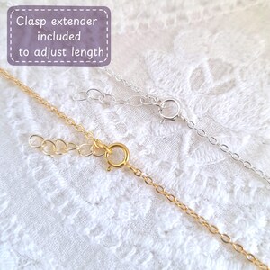 May include: Two gold and silver chains with clasps. The text "Clasp extender included to adjust length" is in a purple box.