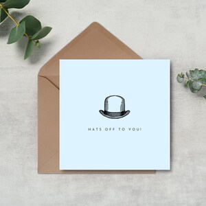 May include: A light blue card with a black and white illustration of a bowler hat. The text "Hats off to you!" is printed below the hat.
