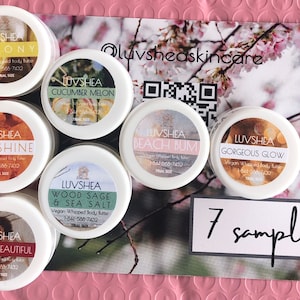 May include: Seven small white jars with lids containing different scented body butters. The jars are labeled with the brand name "LUVSHEA" and the scent of each butter. The jars are arranged in a circle on a pink and white patterned surface. The text "7 samples" is written on a white card in the center of the circle.