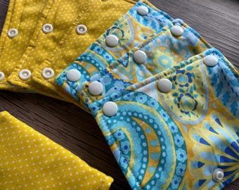 Copriimbracatura Pavlik, abbigliamento per imbracatura Pavlik, stampe reversibili a paisley e pois gialli, chiusura a scatto, pronto per la spedizione.