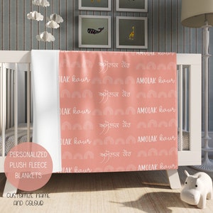 May include: A pink plush fleece baby blanket with a white rainbow and text pattern. The text reads "AMOLAK kaur" and "ਅਮੋਲਕ ਕੌਰ".