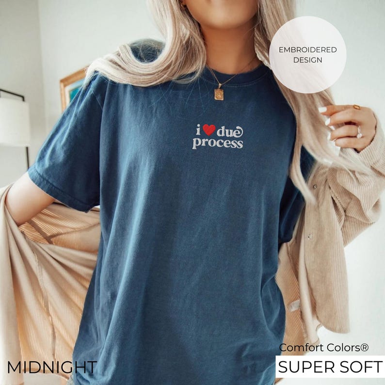 May include: Midnight blue t-shirt with the embroidered text "i ❤️ due process". The shirt has a crew neck and short sleeves. The words "EMBROIDERED DESIGN", "Comfort Colors", and "SUPER SOFT" are also visible.