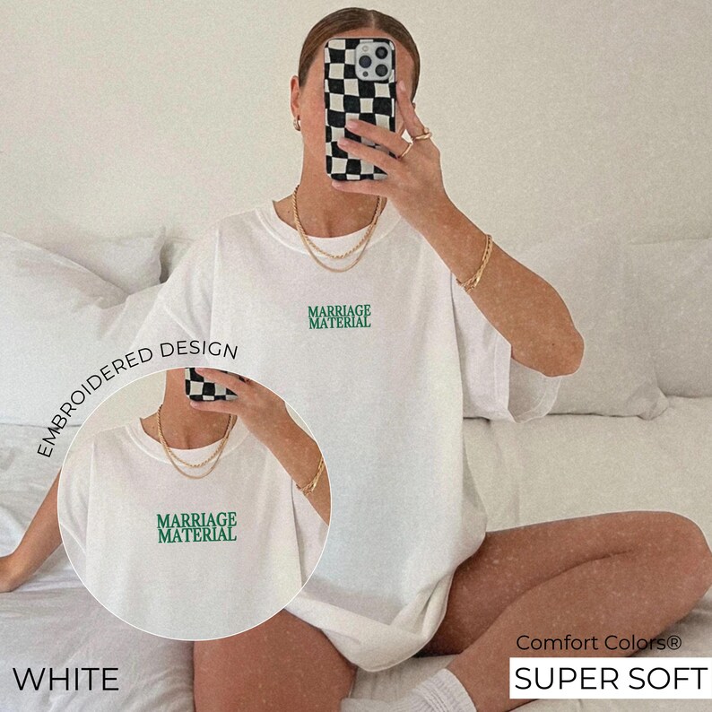 Puede incluir: Camiseta blanca con el texto "Marriage Material" bordado en verde en la parte delantera. La camiseta es s&uacute;per suave y c&oacute;moda.