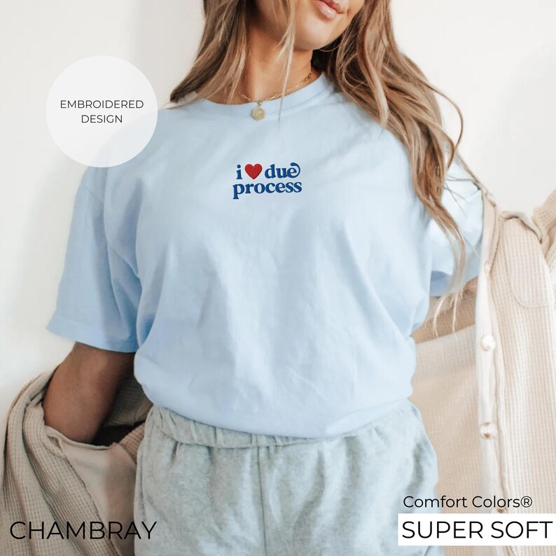 May include: A light blue t-shirt with the embroidered text "i ❤️ due process" in navy blue. The shirt is made of a soft material and has the words "Comfort Colors" and "Super Soft" printed on the bottom right.