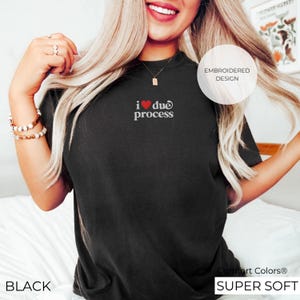 May include: Black t-shirt with the embroidered text "i ❤️ due process". The shirt has a crew neck and short sleeves. The text is in white with a red heart. The shirt is labeled "Comfort Colors Super Soft".