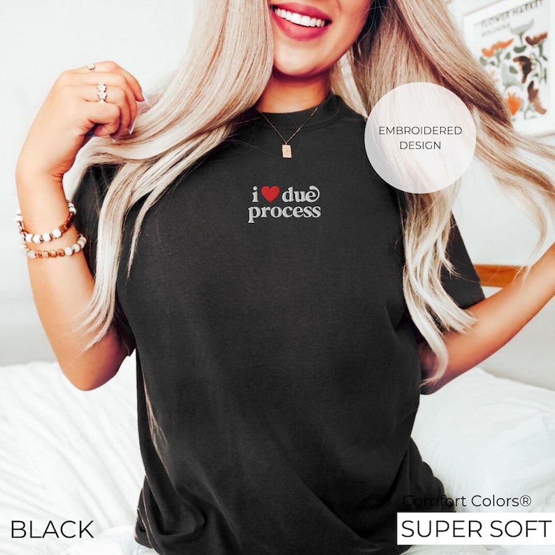 May include: Black t-shirt with the embroidered text "i ❤️ due process". The shirt has a crew neck and short sleeves. The text is in white with a red heart. The shirt is labeled "Comfort Colors Super Soft".