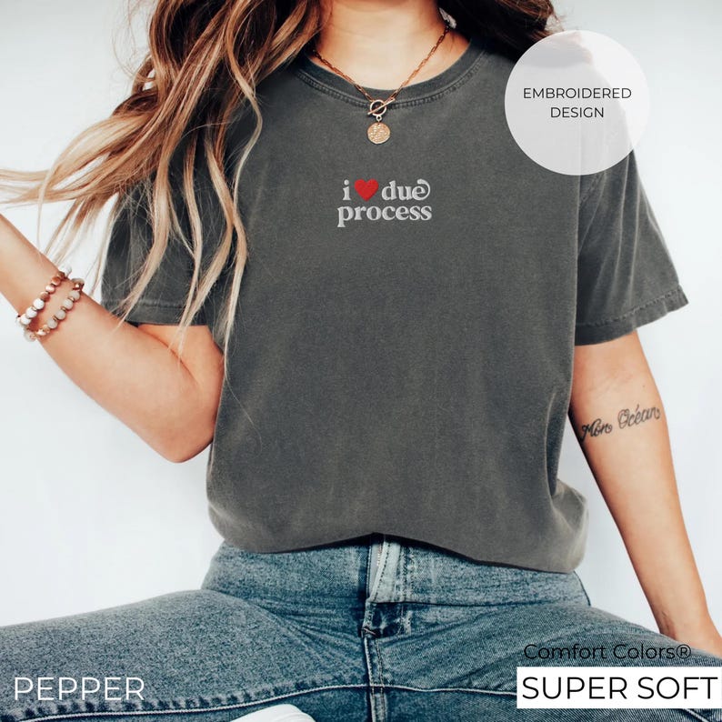 May include: A dark gray t-shirt with the embroidered text "i ❤️ due process". The shirt is a Comfort Colors brand and is labeled "SUPER SOFT". The image also includes the word "PEPPER".