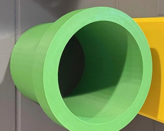 May include: A bright green, cylindrical object with a textured surface. The object has a large opening on one end and a smaller opening on the other. A yellow rectangular shape is visible in the background.