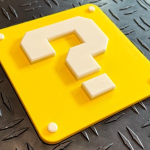 May include: A yellow square with a white question mark in the center. The question mark is made of multiple pieces of white plastic.