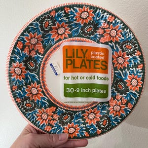 May include: A stack of 30 Lily plastic coated plates, each 9 inches in diameter. The plates feature a dark green background with a repeating pattern of orange and blue flowers. The packaging label reads: LILY PLATES for hot or cold foods.