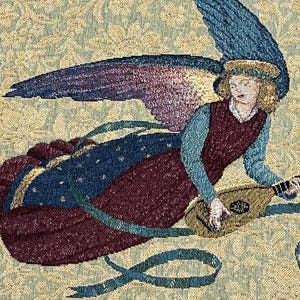 Puede incluir: Tapiz que representa a un &aacute;ngel tocando un la&uacute;d. El &aacute;ngel tiene alas azules y moradas, un vestido granate y una blusa azul. El fondo es un estampado floral en tonos verdes y beige. El tapiz tiene un borde con flecos.