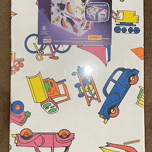 May include: A white cardboard storage box with a colorful design featuring toy vehicles, including cars, trucks, and a bicycle. The box is labeled "Jumbo Storage" and measures 26" x 16" x 11".