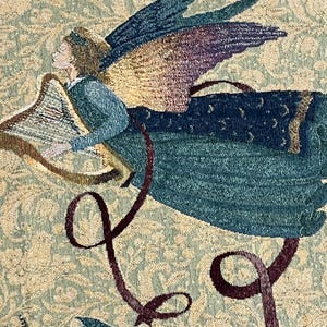 Puede incluir: Primer plano de un tapiz que representa a un &aacute;ngel tocando el arpa. El &aacute;ngel tiene alas azules y moradas y viste de azul. El fondo es un estampado floral en tonos beige y verde. Cintas burdeos y turquesas a&ntilde;aden movimiento.