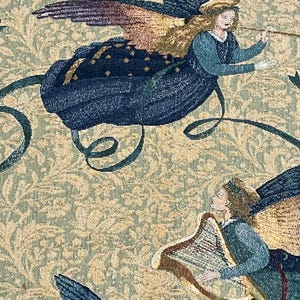 Puede incluir: Tapiz con dos &aacute;ngeles alados, tocando una trompeta y un arpa. Los &aacute;ngeles visten t&uacute;nicas azules sobre un fondo beige con un patr&oacute;n floral. Las alas son una mezcla de azul, dorado y morado.