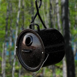 May include: Black metal birdhouse with a round shape and a small entrance hole. The birdhouse is hanging from a metal hook.