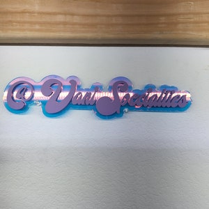 May include: A blue and purple sign with the text "@Dani Specialties" in pink lettering.