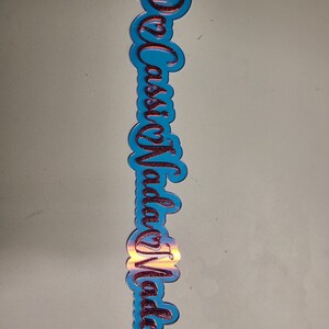 May include: A blue acrylic sign with the words "Casa Vida" written in red glitter.