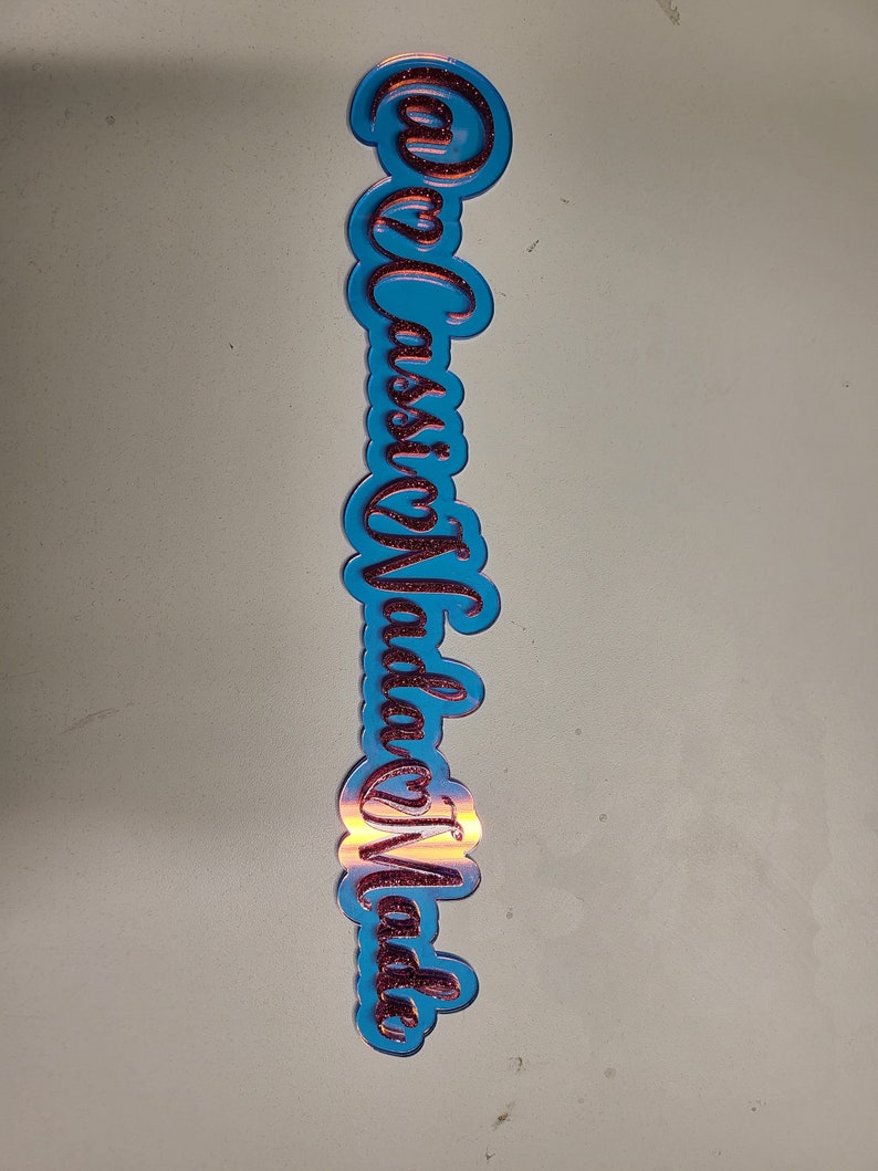 May include: A blue acrylic sign with the words "Casa Vida" written in red glitter.