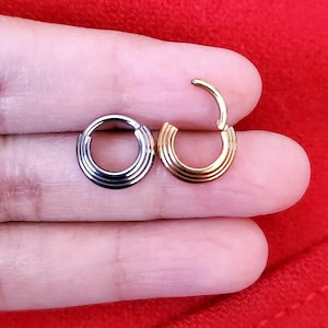 May include: Two hoop earrings, one silver and one gold, with a grooved design.