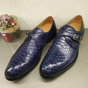 May include: A pair of blue leather shoes with a buckle fastening. The shoes have a snakeskin pattern and a pointed toe.