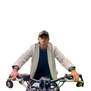 May include: A person wearing a white textured jacket and a black cap, sitting on a black motorcycle. The motorcycle has black handlebars and a black seat. The background is white.