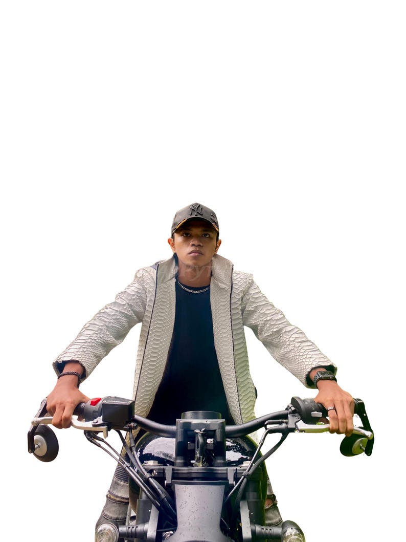 May include: A person wearing a white textured jacket and a black cap, sitting on a black motorcycle. The motorcycle has black handlebars and a black seat. The background is white.