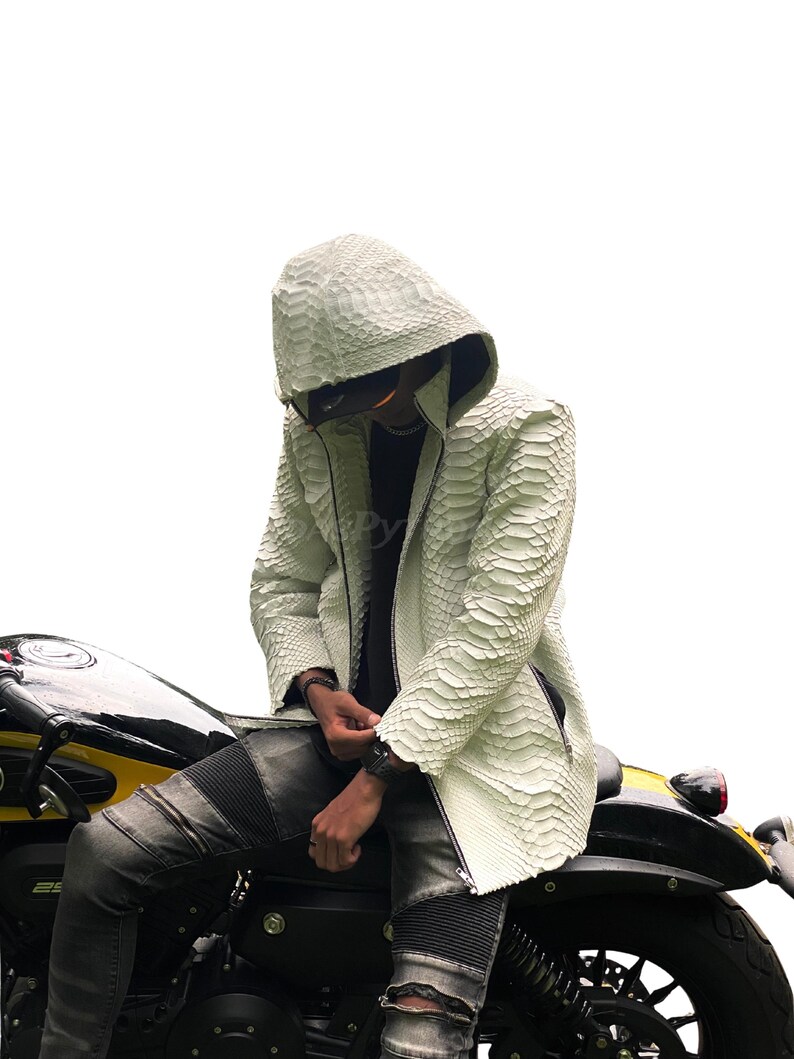 May include: White textured hooded jacket with a zip. The jacket is worn with black jeans and a black motorcycle. The jacket's texture resembles snakeskin.