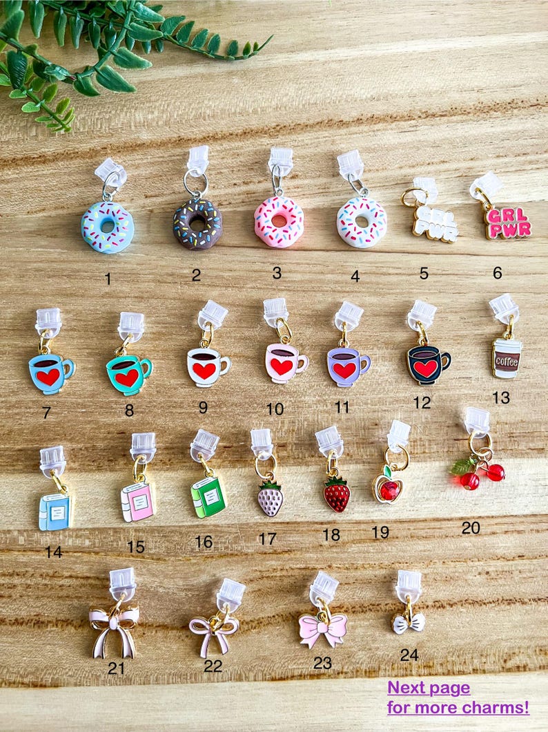 May include: Twenty-four different charm designs for a zipper pull or bag charm. The charms include donuts, coffee mugs, books, strawberries, cherries, and bows. The charms are all gold-colored with colorful enamel details.