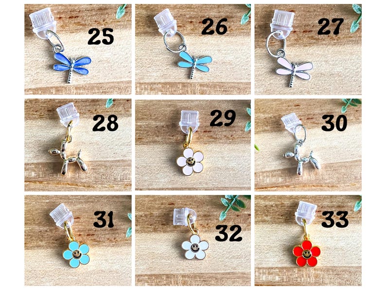 May include: A set of 10 charm pendants for keychains or jewelry making. The charms include a butterfly, a flower with a smiley face, and a balloon animal. The charms are numbered 25 through 33.