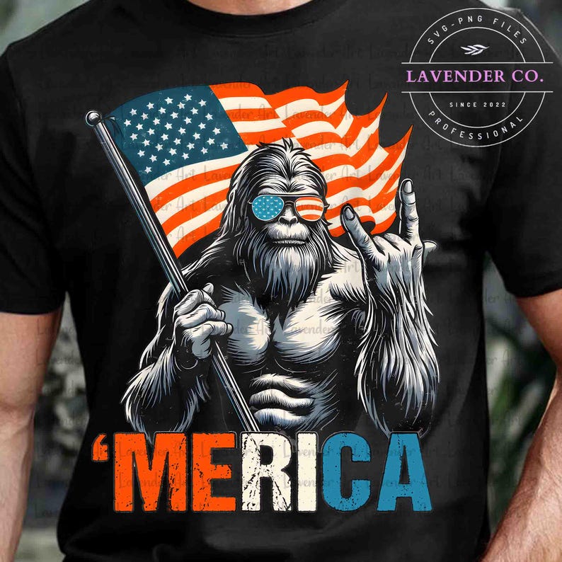Puede incluir: Camiseta negra con un gr&aacute;fico de una criatura parecida a Pie Grande con gafas de sol con un dise&ntilde;o de bandera estadounidense. La criatura sostiene una bandera estadounidense y hace un gesto con la mano. La palabra "'MERICA" est&aacute; impresa en rojo, blanco y azul.
