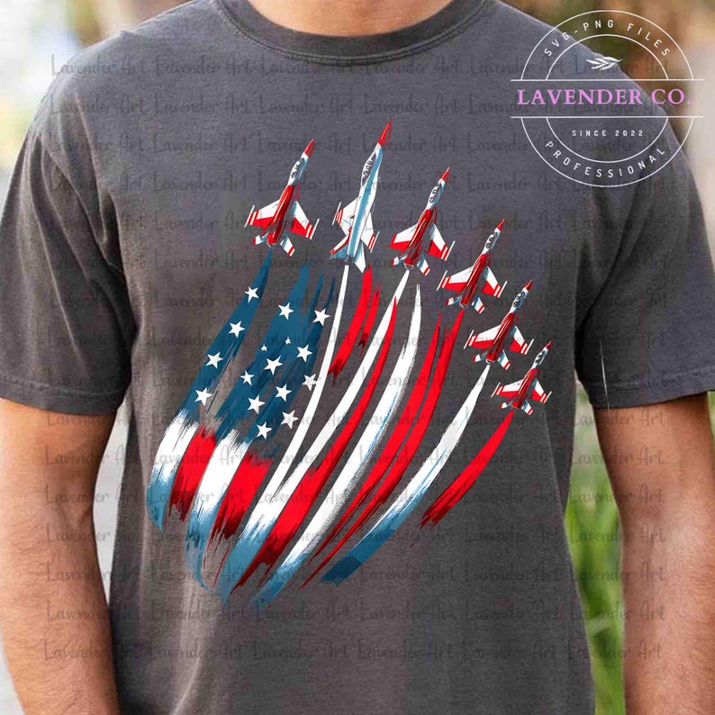 May include: Gray t-shirt featuring a patriotic design with jets and the American flag. The jets are red, white, and blue, with the flag's stars and stripes forming a dynamic visual. The shirt has the text "LAVENDER CO PROFESSIONAL SINCE 2022".
