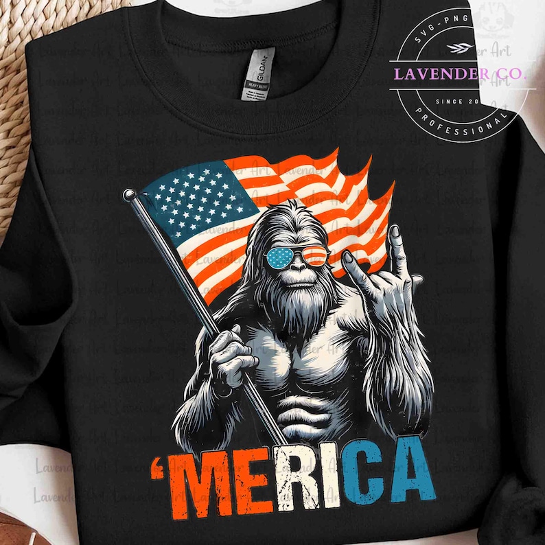 Puede incluir: Sudadera negra con un gr&aacute;fico de un personaje de Bigfoot con gafas de sol con un dise&ntilde;o de bandera estadounidense. El Bigfoot sostiene una bandera y hace un gesto de mano de rock-on. La palabra "'MERICA" est&aacute; impresa en rojo, blanco y azul.