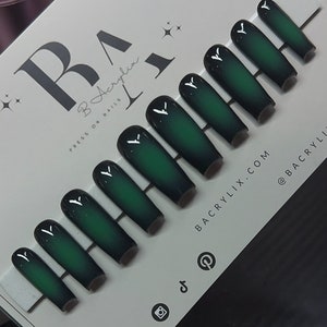 May include: Set of ten green and black ombre press-on nails. The nails are long and have a coffin shape. The nails are arranged in a row on a white surface. The text "B Acrylix Press On Nails" is visible in the top left corner of the image. The text "BAcrylix.com @BAcrylix" is visible in the bottom right corner of the image.