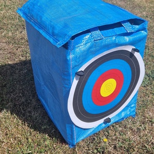 May include: Blue archery target bag with a white and black archery target with red, yellow, and blue rings.