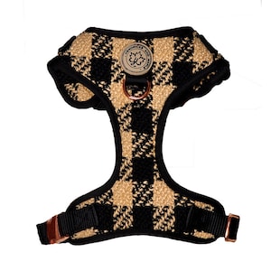 May include: A black and tan plaid dog harness with a rose gold metal buckle and a small leather tag that says "Hendricks and Max".