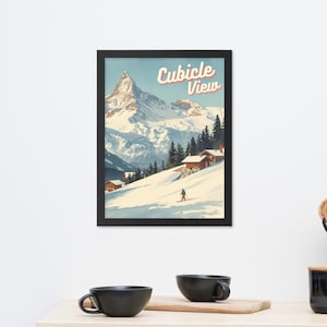 May include: Framed art print featuring a snowy mountain landscape with the text "Cubicle View" in a retro style. The artwork depicts a skier, cabins, and evergreen trees on a snow-covered slope, under a blue sky.