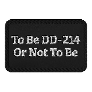 Puede incluir: Parche rectangular negro con texto bordado en blanco. El texto dice "To Be DD-214 Or Not To Be". El parche tiene un borde cosido.