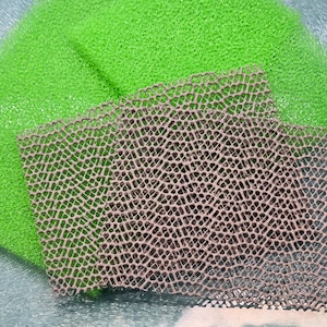 May include: Two green foam pads and a brown mesh pad. The mesh pad has a diamond pattern.